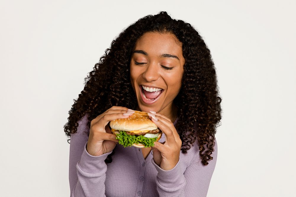 Happy woman eating a hamburger