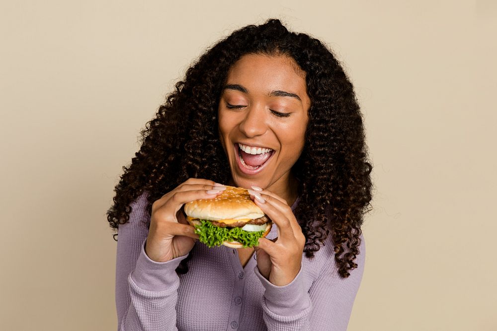 African American woman eating a hamburger