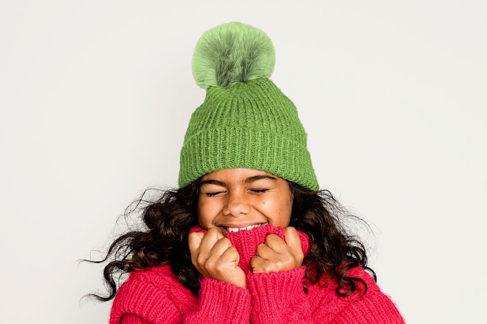 Cute girl in knitted hat, isolated on off white
