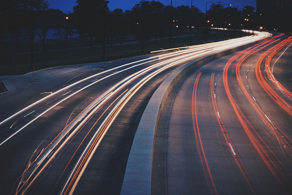 White and red light trails on a highway in the evening. Original public domain image from Wikimedia Commons