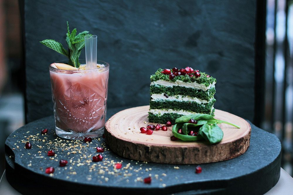 Layered stack of herbs, cheese, and pomegranate seeds with a fruity drink. Original public domain image from Wikimedia…