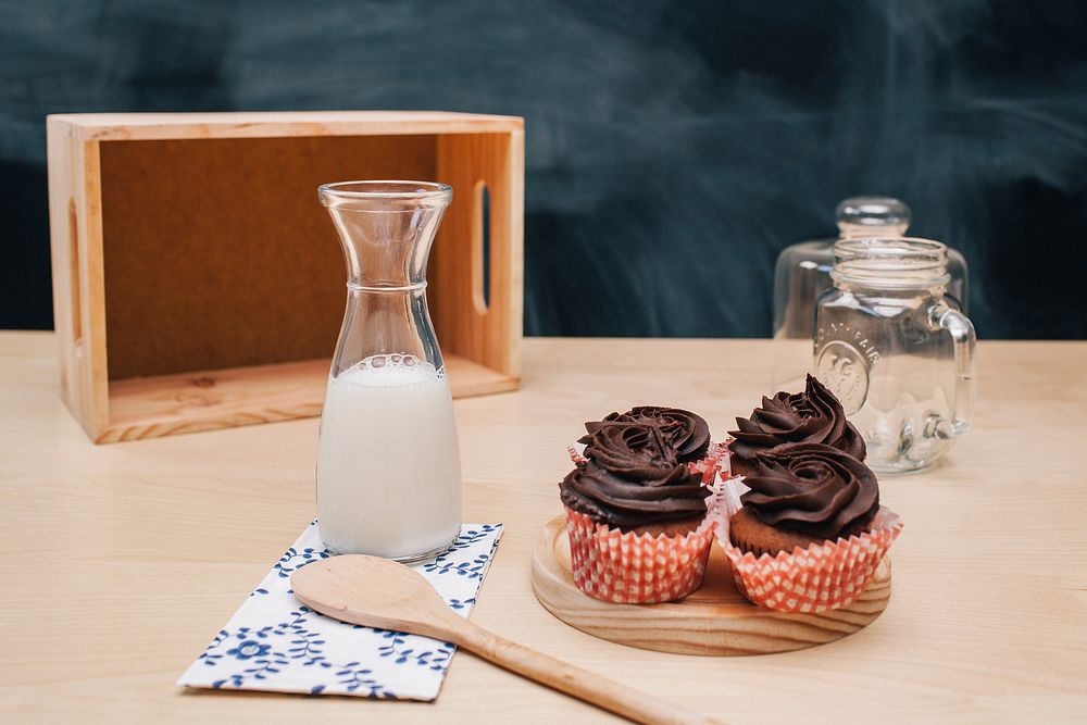 Homemade cupcakes with chocolate frosting and milk. Original public domain image from Wikimedia Commons