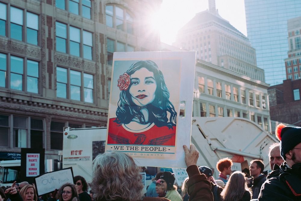 People hold up protest signs at the Women's March in Boston. Original public domain image from Wikimedia Commons