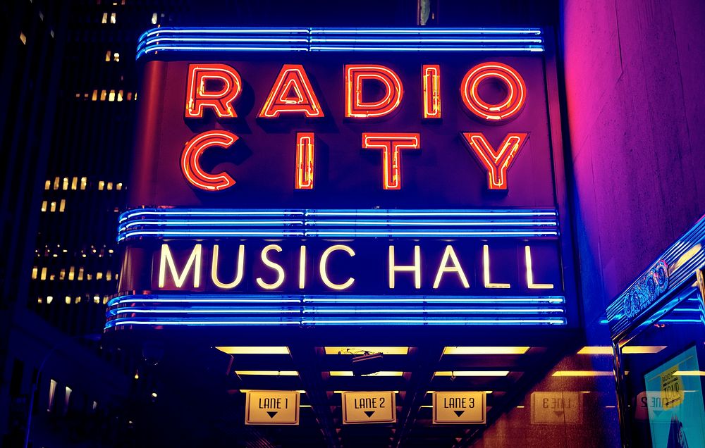 A large neon sign reads “Radio City Music Hall”. Original public domain image from Wikimedia Commons