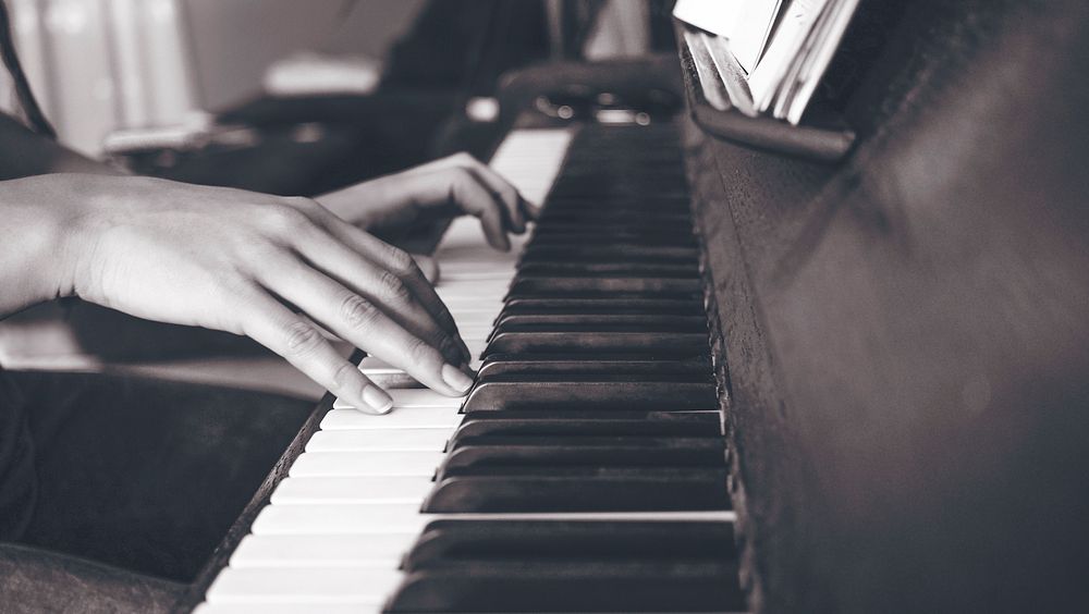 Woman's hands playing piano, black and white shot. Original public domain image from Wikimedia Commons