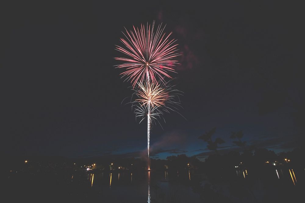 Colorful fireworks over a body of water at night. Original public domain image from Wikimedia Commons