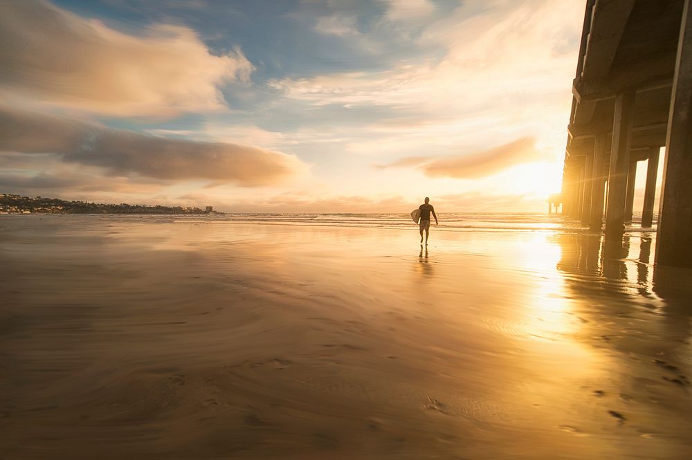 Surfer walking on beach,surfboard,sunset. Original public domain image from Wikimedia Commons