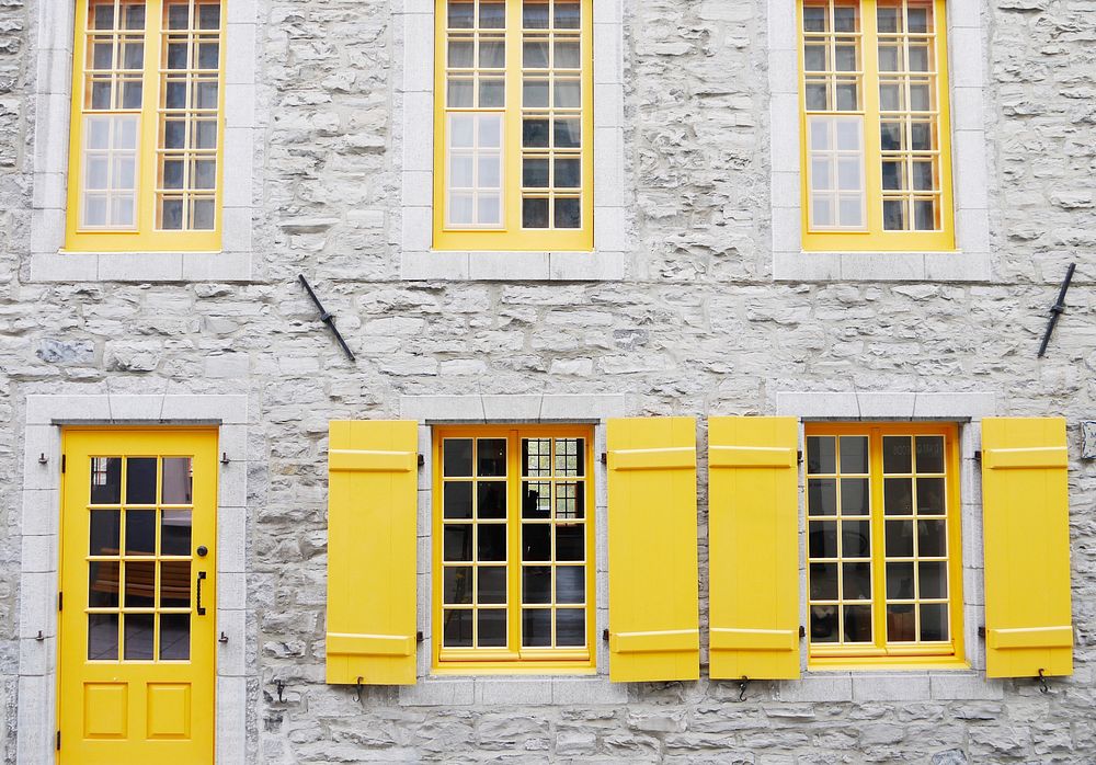 Yellow door and windows with yellow shutters in a white facade in Québec City. Original public domain image from Wikimedia…
