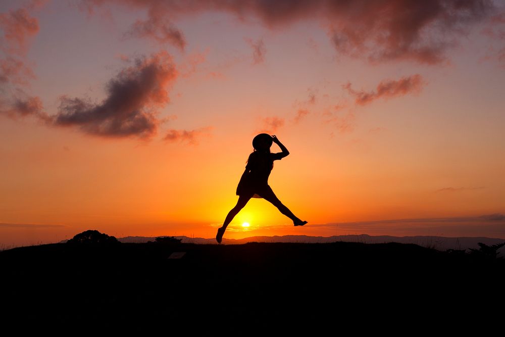 Girl jumping in front of sunset. Original public domain image from Wikimedia Commons