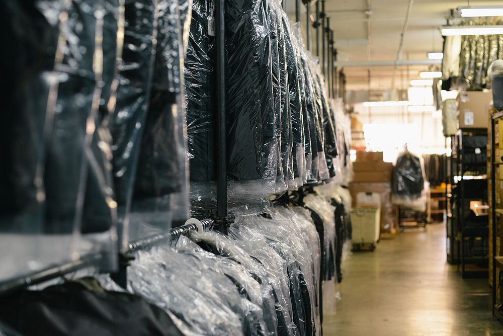 Suits in plastic wrap on hangers at a dry cleaner's. Original public domain image from Wikimedia Commons