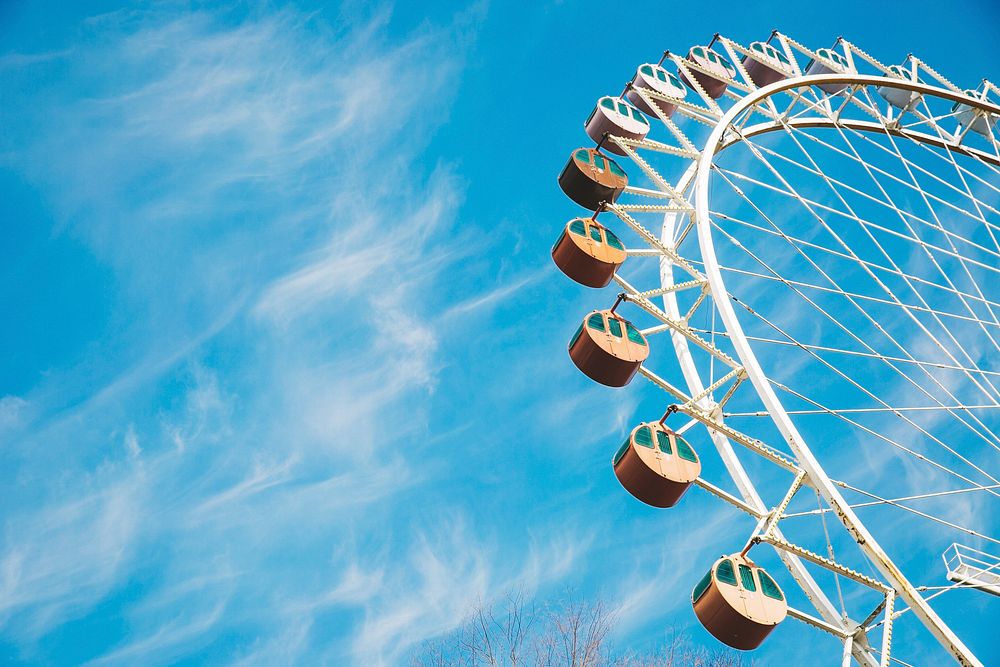A Ferris wheel at a fairground against a blue sky. Original public domain image from Wikimedia Commons