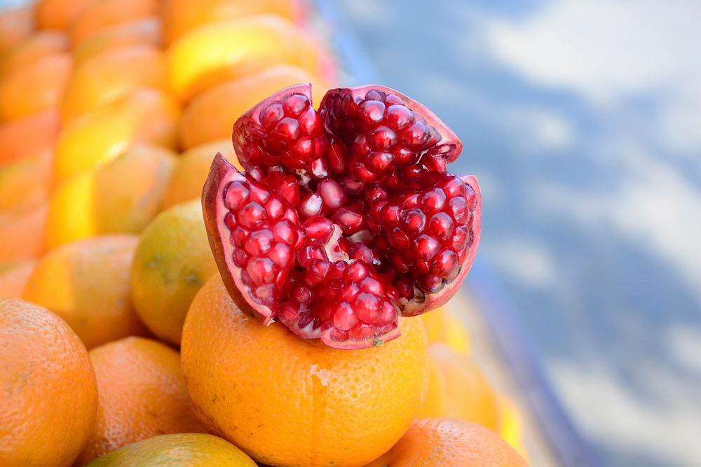 Pomegranate on a pile of mandarins. Original public domain image from Wikimedia Commons