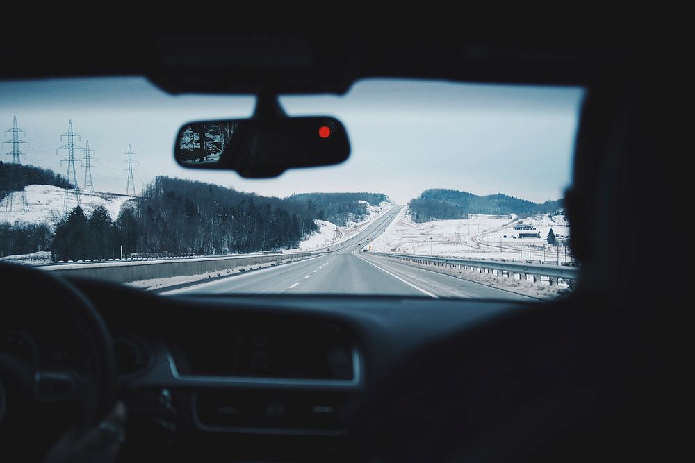 View through the windscreen from the Audi interior on the two-lane highway during Winter.. Original public domain image from…