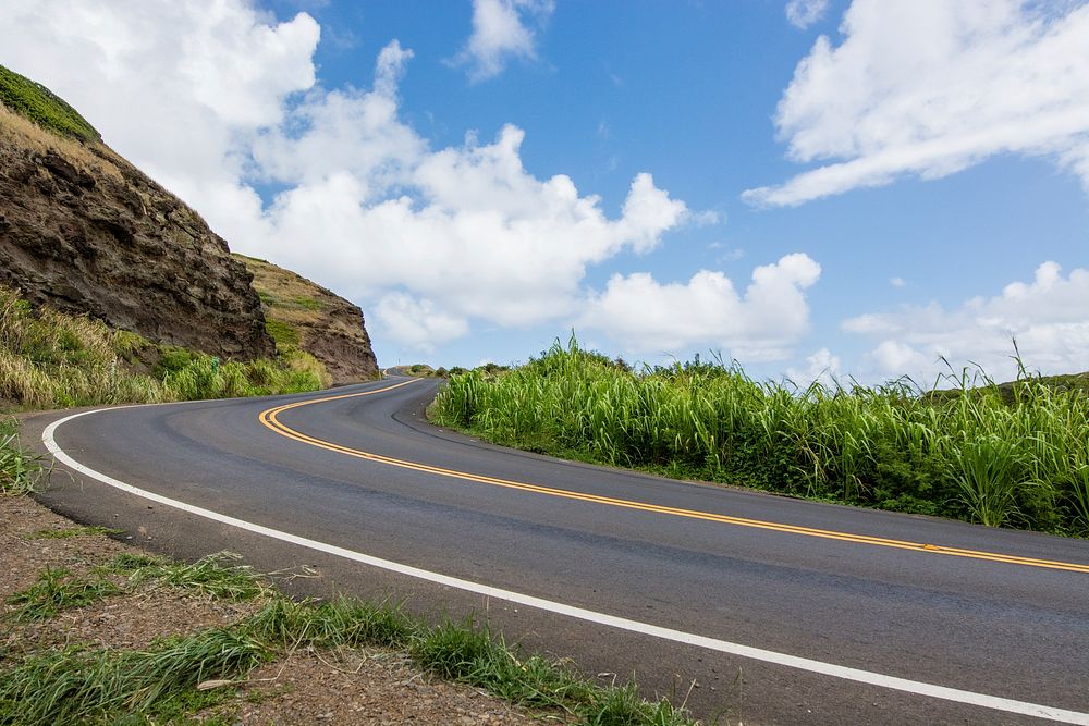 A winding road along the side of a cliff and grass on the other side in Maui. Original public domain image from Wikimedia…