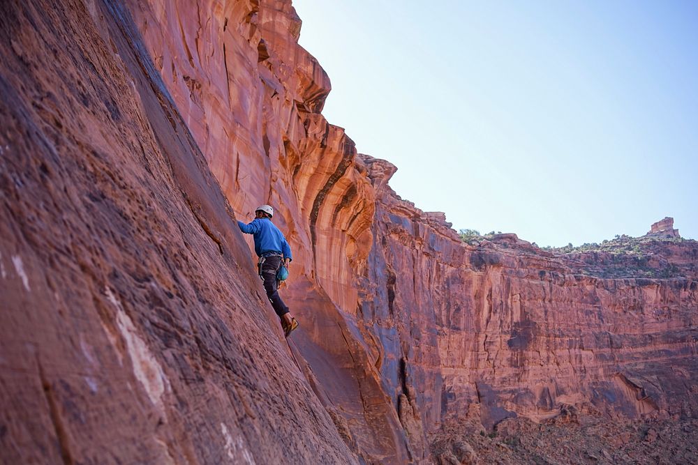 Extreme climber scales the side of a rocky mountain. Original public domain image from Wikimedia Commons