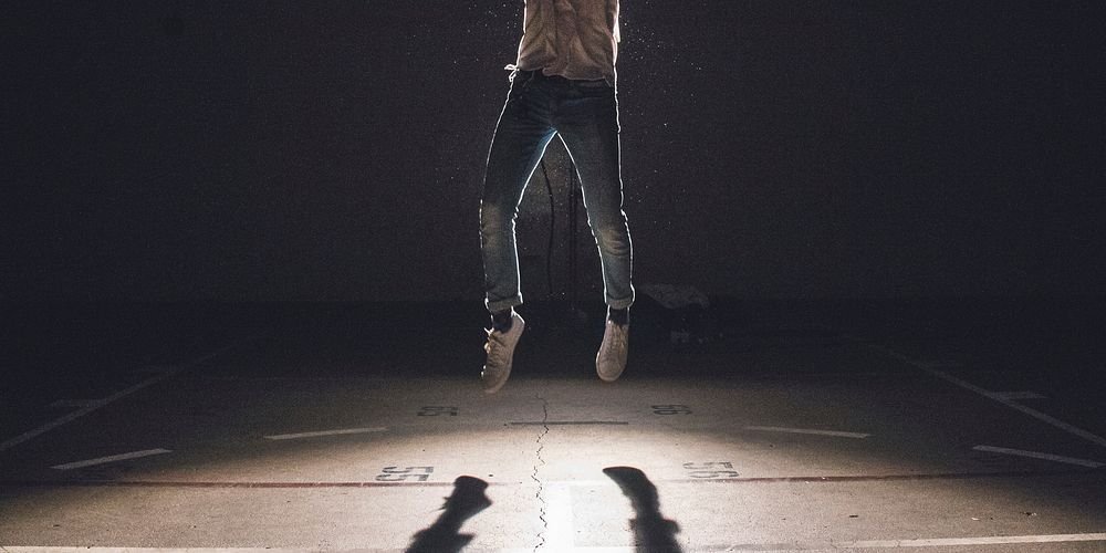 Person in jeans and sneakers jumping off of floor with shadow below. Original public domain image from Wikimedia Commons