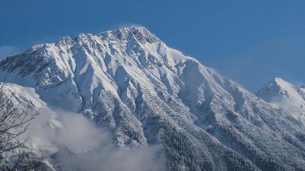A tall snow-covered peak in Innsbruck. Original public domain image from Wikimedia Commons
