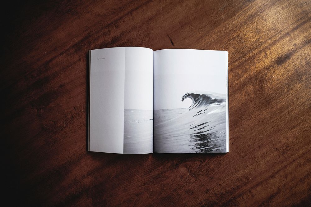 An open book with a photograph of a sea wave on its pages. Original public domain image from Wikimedia Commons