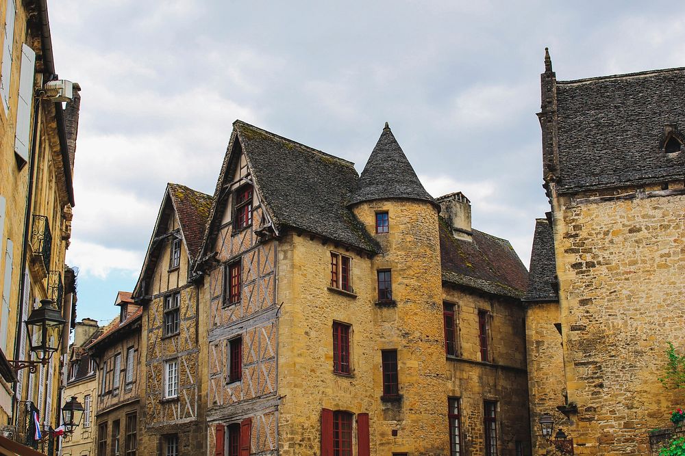 A landscape view of old buildings with windows and a tower in Sarlat P&eacute;rigord Foie Gras. Original public domain image…