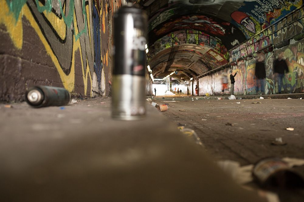 Spray cans sit on curb on Leake Street graffiti tunnel. Original public domain image from Wikimedia Commons
