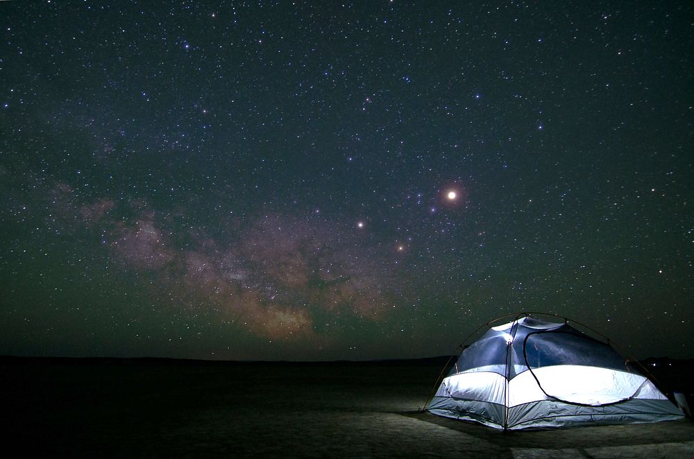 Campers pitch a tent to stargaze at night in Alvord Desert. Original public domain image from Wikimedia Commons
