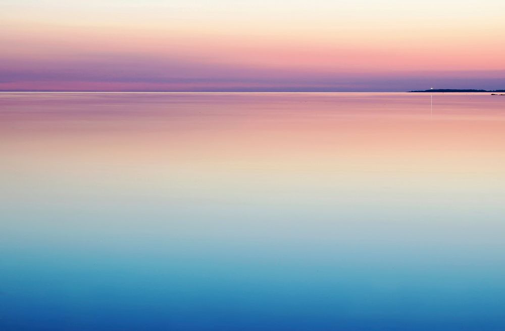 A peaceful and serene pastel pink and purple sunset reflecting on still and calm water. Original public domain image from…