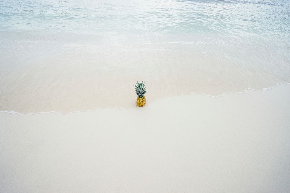 Pineapple on white beach, waves. Original public domain image from Wikimedia Commons