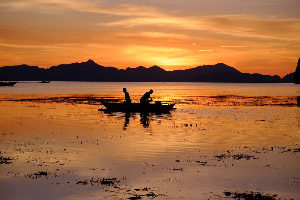 Fisherman, boat, beach,sunset, reflection. Original public domain image from Wikimedia Commons