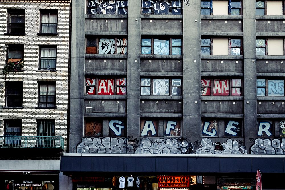 Urban building with balcony and graffiti covered windows and text. Original public domain image from Wikimedia Commons