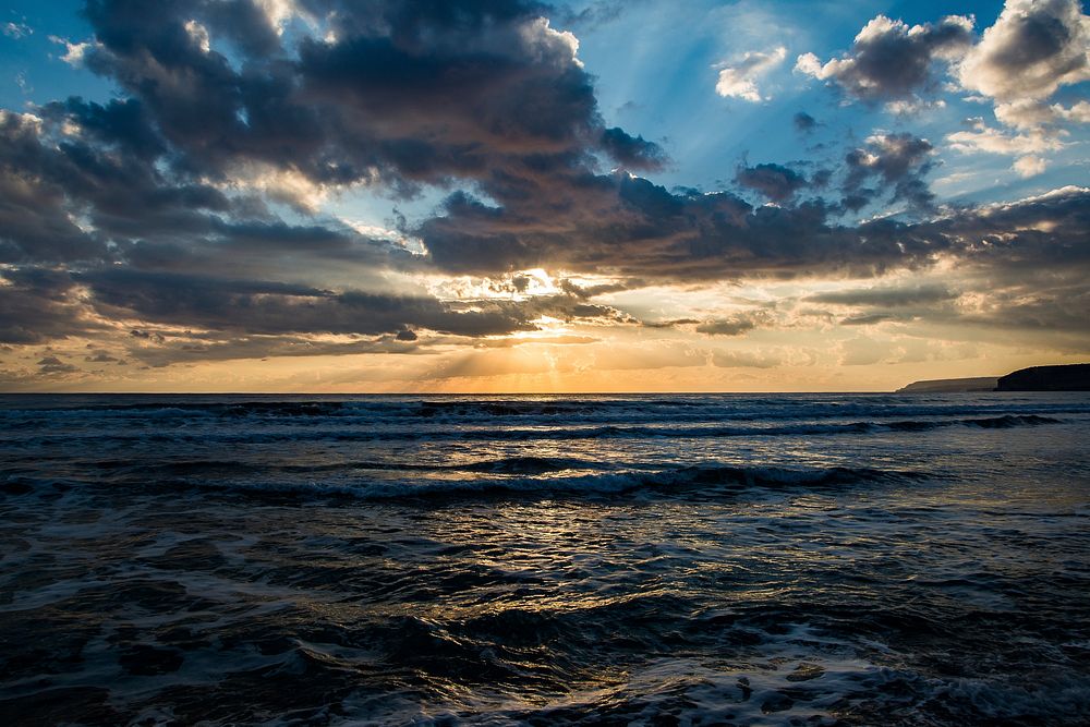 View of the sun shining through clouds from the Kourion Beach. Original public domain image from Wikimedia Commons
