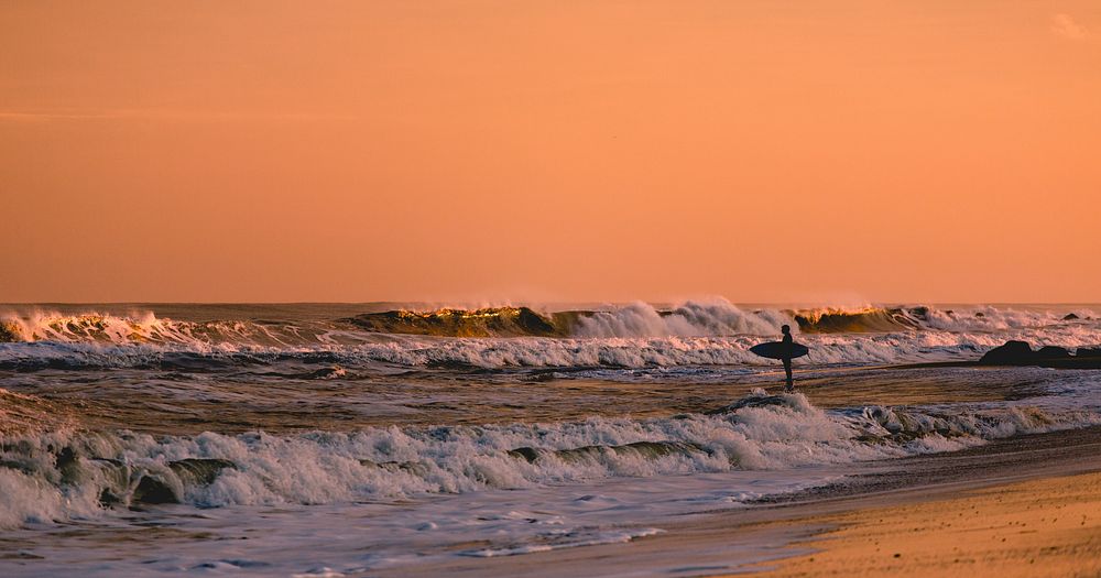 Surfer on the beach sunset waves. Original public domain image from Wikimedia Commons
