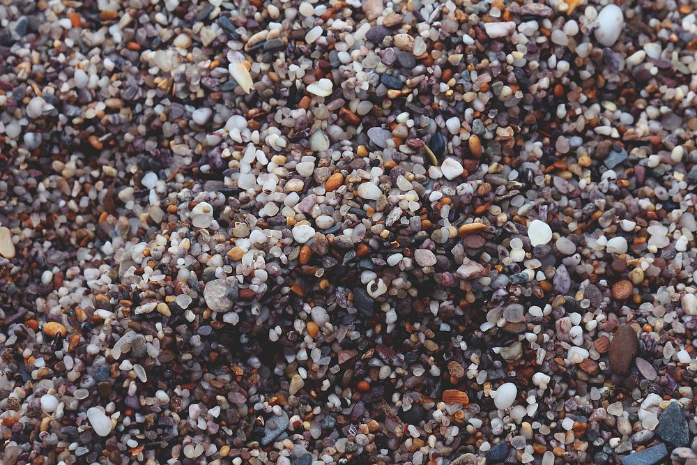 A top view of a large number of pebbles of various color, shape and size. Original public domain image from Wikimedia Commons