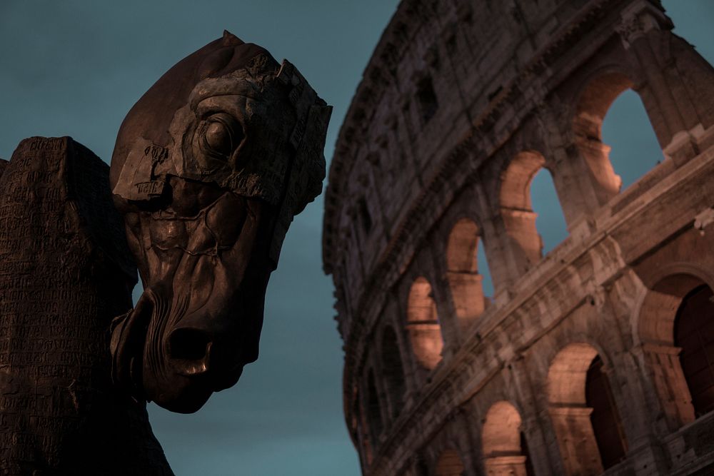 A horse head sculpture next to the Colosseum at dusk. Original public domain image from Wikimedia Commons