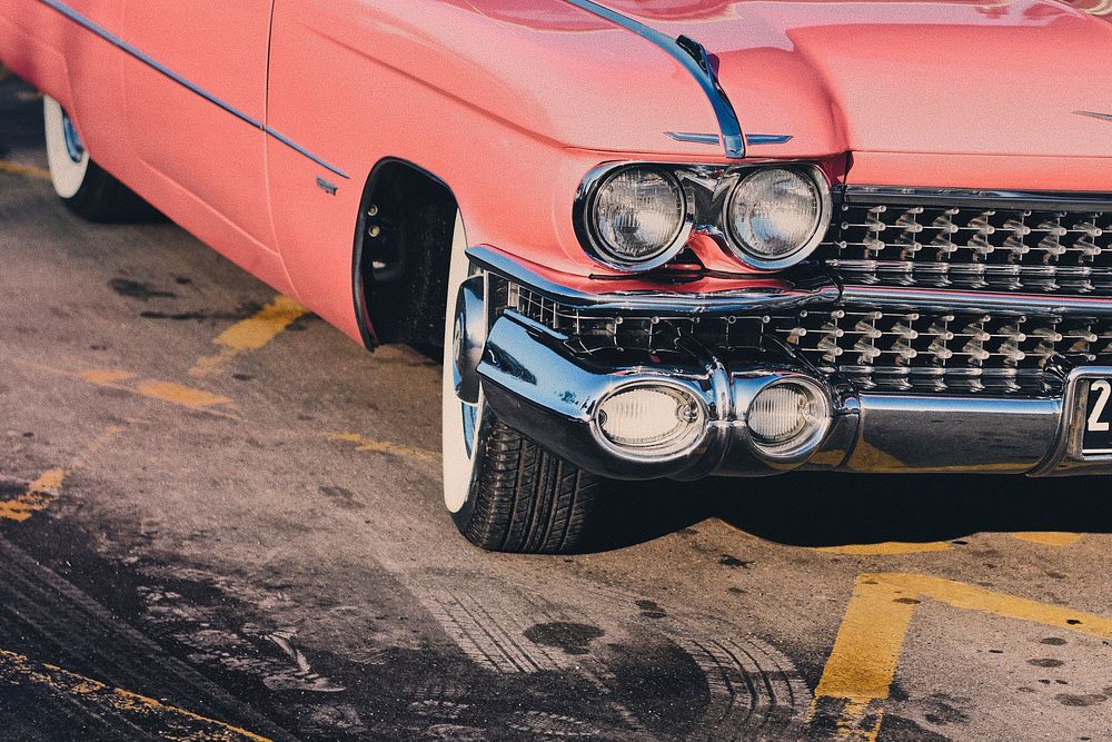 A shot of the front right view of a classic 1959 pink Cadillac behind the skid marks.. Original public domain image from…