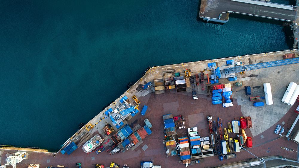 An overhead shot of Saint Peter Port with shipping containers next to the calm sea.. Original public domain image from…
