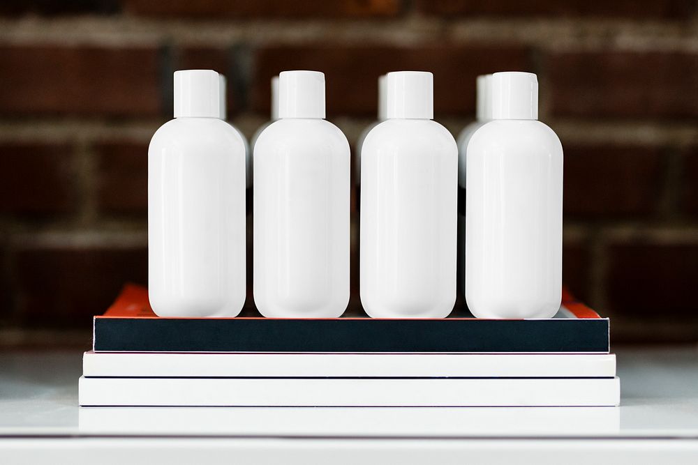 Four beauty product bottles on a shelf 