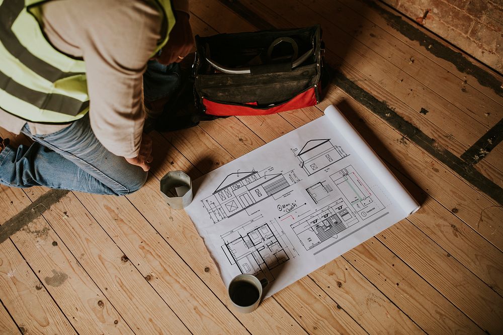 Contractor reading floor plan at a construction site