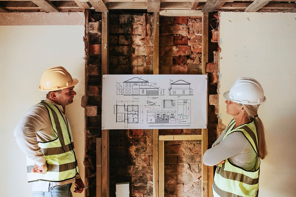 Contractor coworkers looking at floor plan at a construction site
