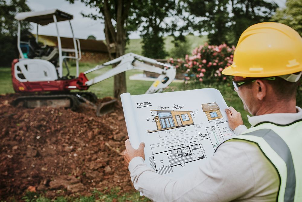 Contractor holding a floor plan at a construction site
