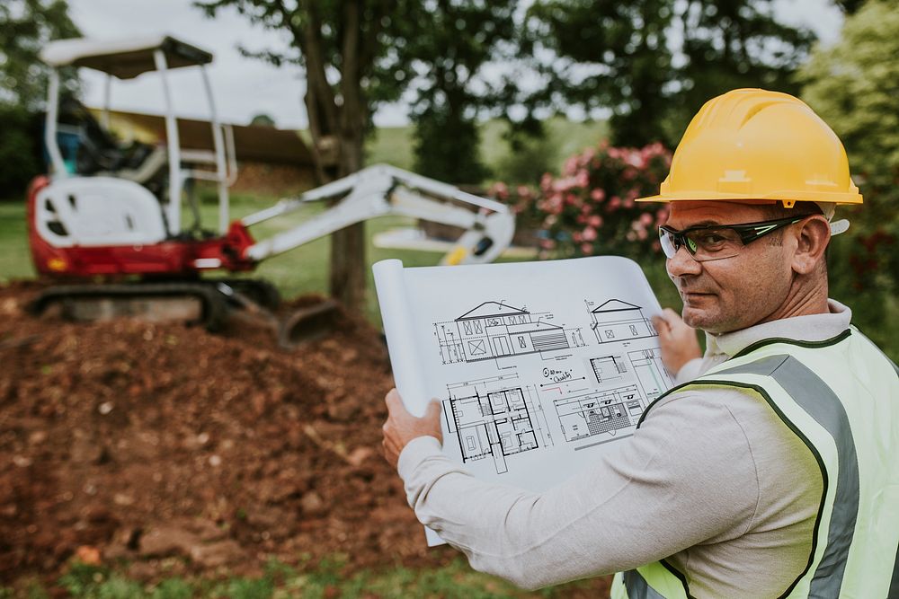 Construction worker reading a floor plan at the site