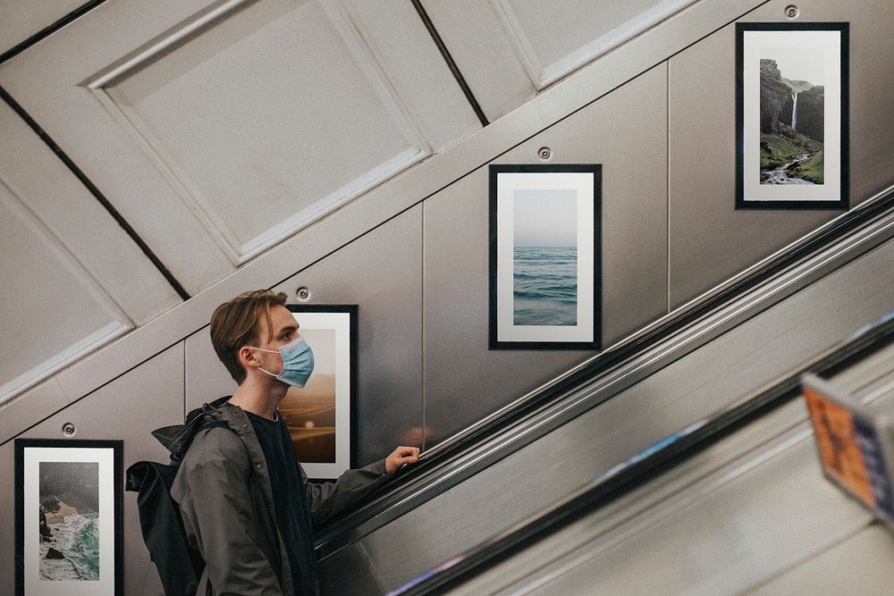 Man wearing mask on underground escalator 