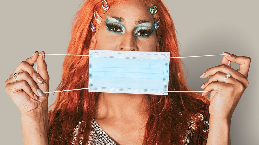 Drag show artist holding blue face mask in the new normal