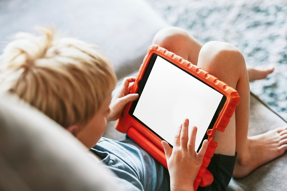 Young blond boy using tablet