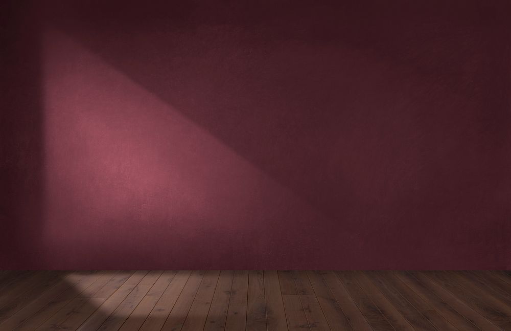 Burgundy red wall in an empty room with a wooden floor