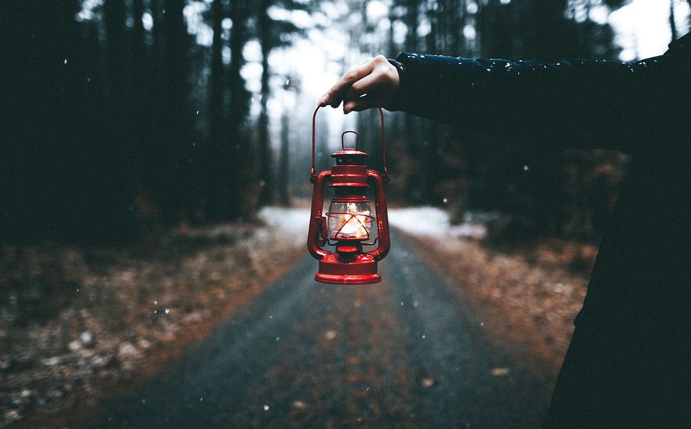 Hand holding lantern at adirondack mountains