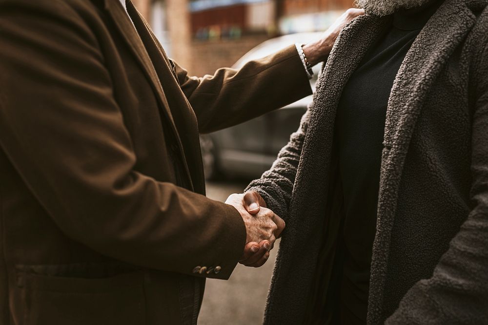 Two men shaking hands in the street