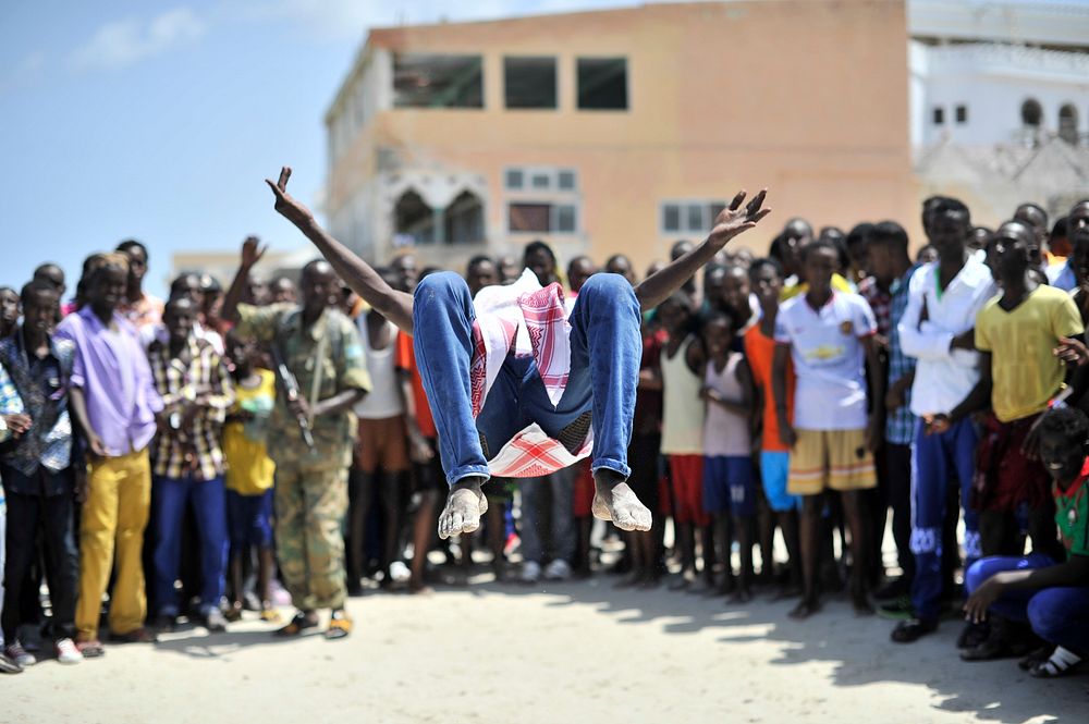 Youth watch an acrobat somersaulting at Lido beach in Mogadishu, Somalia on Eid Al-Fitr day, which marked the end of the…