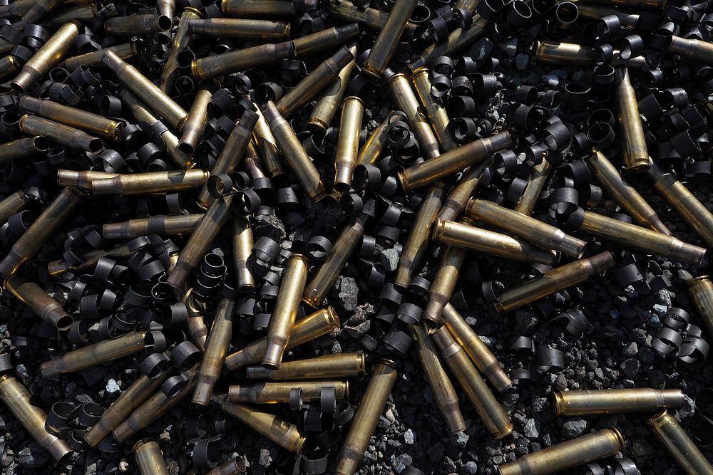 Expended .50 Caliber shells and links lay scattered on the ground. Original public domain image from Flickr