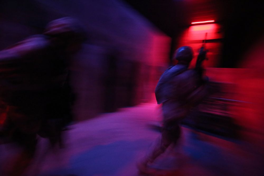 U.S. Air Force Airmen from the New Jersey Air National Guard's 177th Security Forces Squadron maneuver through an indoor…