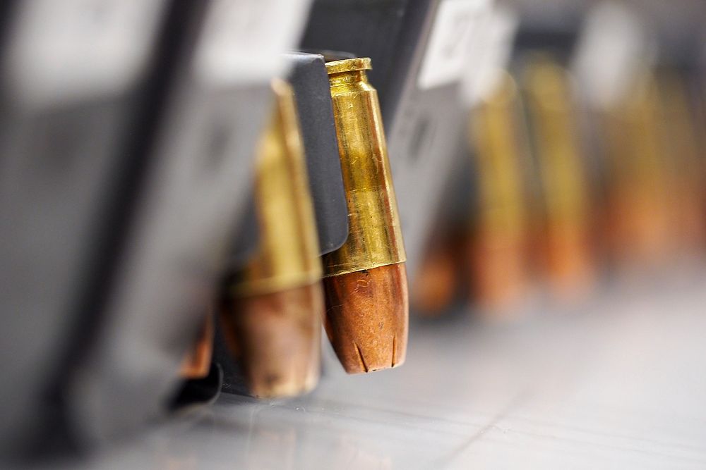 Magazines of 9mm ammunition are lines up on a table at the 673d Security Forces Squadron armory before issue to security…